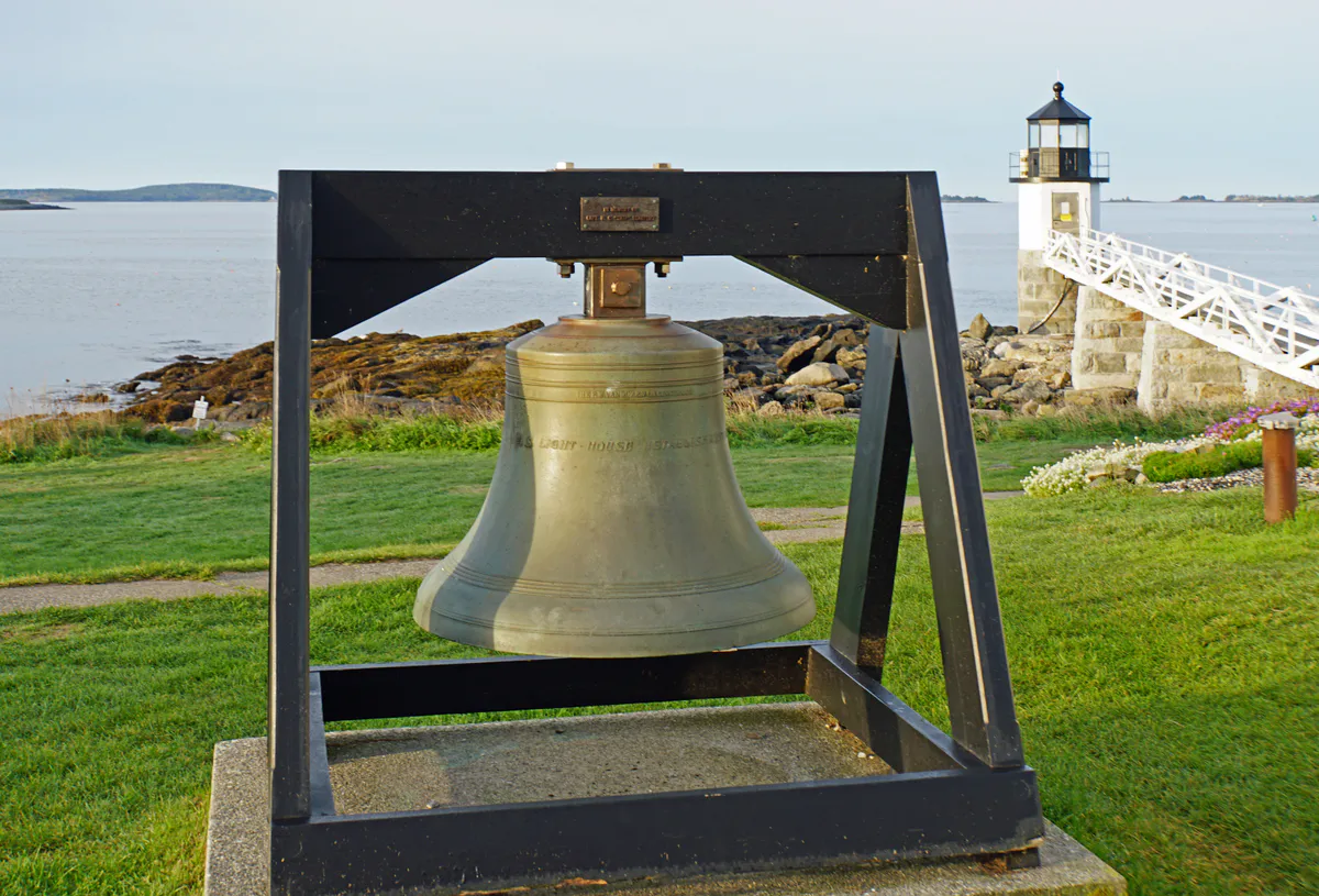 Marshall Point Light in St. George, Maine, a small white tower connected to the shore by a covered wooden walkway