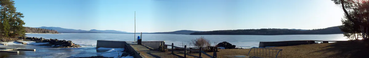 Panoramic view of Mooselookmeguntic Lake from Oquossoc, Maine, showing the lake surrounded by forested mountains in the Rangeley Lakes region