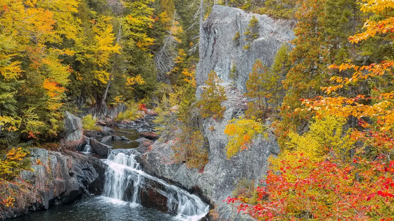 Autumn foliage above Buttermilk Falls in Gulf Hagas, Maine.